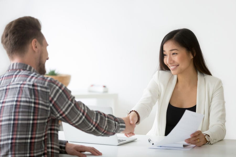 Young man and woman shaking hand in an interview