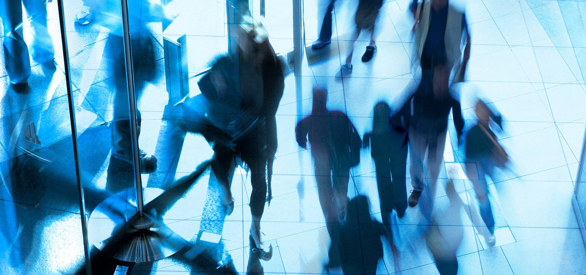 People walking through revolving door in office building